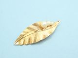 gold leaf brooch on a blue background