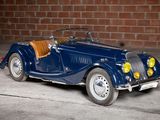 a blue car that is parked in front of a brick wall