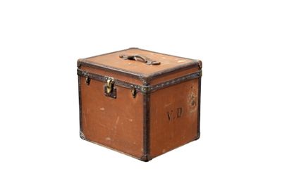 une vieille valise posée sur une surface blanche