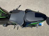 a green and black motorcycle parked in a parking lot