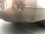 a reflection of a person holding a cell phone in the rear of a car