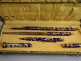 three pens in a case that are sitting on a table