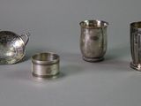 several silver cups and spoons are lined up on a table