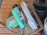 quelques outils sont posés sur une table en bois à côté d'un pot de peinture