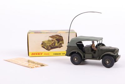 a toy army jeep with a driver in front of a boxed box