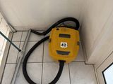 un sèche-cheveux jaune posé par terre près d'une fenêtre