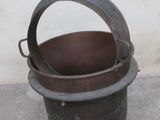 a bucket that is sitting on the ground next to a wall