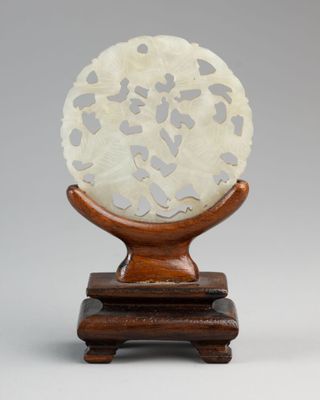an image of a white and brown sculpture on a wooden stand