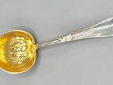 une image représentant une cuillère en argent ornée d'une fleur jaune