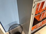 a trash can sitting in the corner of a kitchen