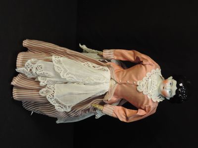 a doll that is standing on a black surface