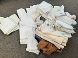 une pile de serviettes pliées posée par terre à côté d'une valise