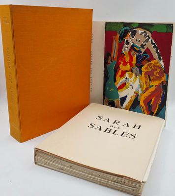 an orange book sitting next to a stack of books on a white surface