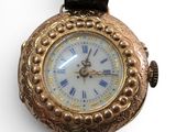 a gold wrist watch with roman numerals on the face
