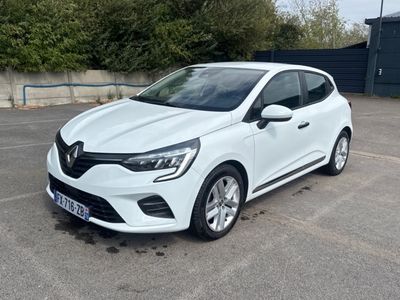 une voiture blanche garée sur un parking près d'une clôture