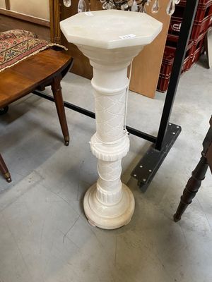 a white pedestal sink sitting in a room with chairs