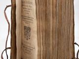 un vieux livre ouvert sur une surface blanche