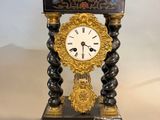 a black and gold clock sitting on top of a table