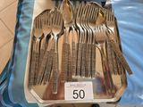 five forks and five spoons sitting on a tray