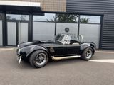 an image of a black sports car parked in front of a building