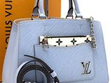 a blue handbag with a belt and a box