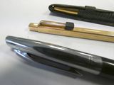 two pens and a pen holder on a table