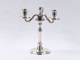 a silver plated candelab with three candles on a stand