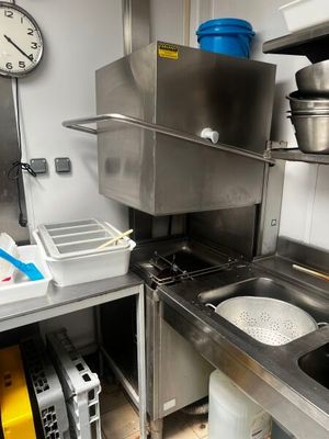 une cuisine équipée d'un évier, d'une cuisinière et d'une horloge