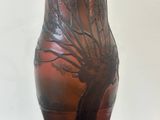 a brown vase with a tree on it sitting on a table