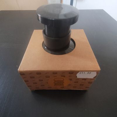 a box with a black knob on it on a table
