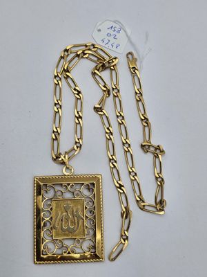 gros plan d'un collier en or sur une surface blanche