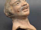 a close up of a clay figurine of a man with a mustache