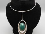 un collier orné d'une pierre verte sur un mannequin noir