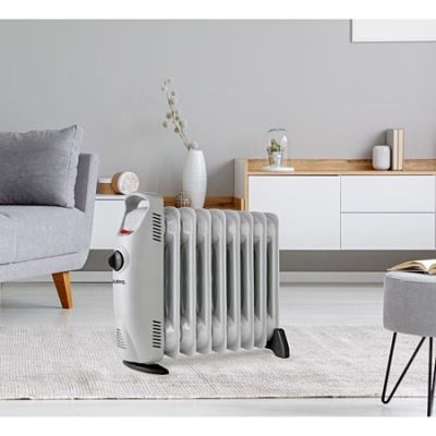 un radiateur blanc posé sur un tapis, à côté d'un canapé