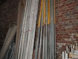 several pieces of metal are stacked against a brick wall in a room