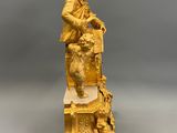 an image of a gold statue of a man sitting on a chair