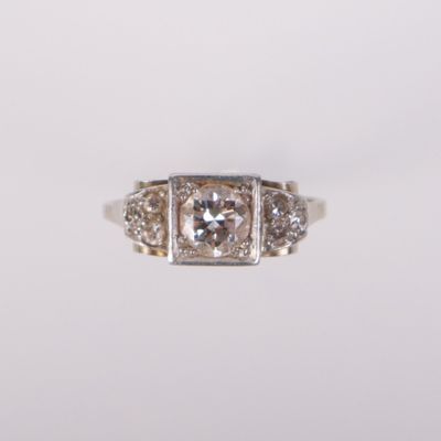 a close up of a diamond ring on a white surface