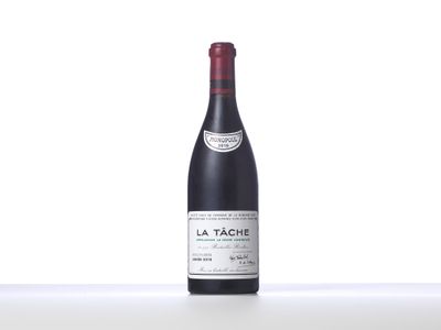 a bottle of red wine sitting on top of a white table