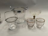 a silver and glass ice bucket and glasses on a table