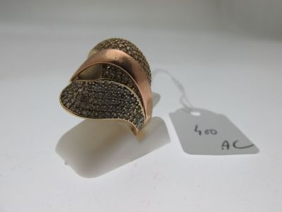 une image représentant une bague en or sertie de diamants noirs sur un fond blanc