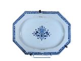 une assiette bleue et blanche sur un support sur fond blanc