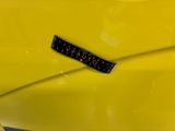 a close up of a yellow car with a sticker on it