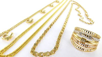 several different types of gold necklaces and bracelets on a white surface