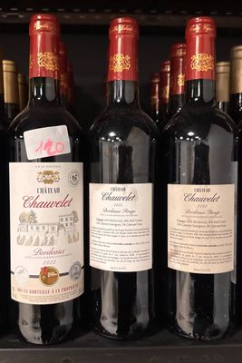 several bottles of wine are lined up on a shelf in a store