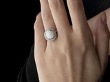 someone is wearing a ring that has a white stone on it