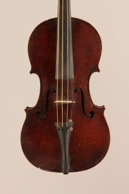 un vieux violon posé sur une surface blanche