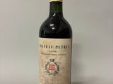 an old bottle of wine sitting on top of a white table