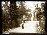 black and white photo of a little boy walking down a road