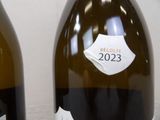 two bottles of wine with labels on them on a table