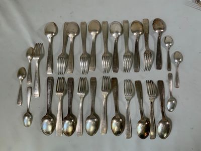 un grand nombre de cuillères et de fourchettes disposées sur une table
